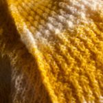 detail of knit yellow and white blanket